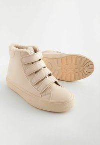 Tan hoge sneakers met nepbontvoering, voorzien van drie klittenbandsluitingen, een gestructureerde rubberen zool en een soepel leerachtig bovenwerk.