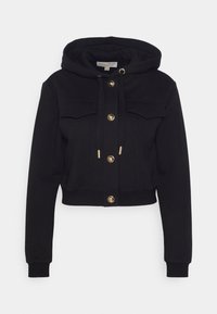 Crop hoodie nera realizzata in tessuto morbido, con cappuccio regolabile tramite cordino, chiusure con bottoni dorati e due tasche frontali. Texture liscia in tutto il capo.
