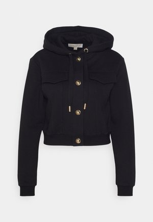 Crop hoodie nera realizzata in tessuto morbido, con cappuccio regolabile tramite cordino, chiusure con bottoni dorati e due tasche frontali. Texture liscia in tutto il capo.