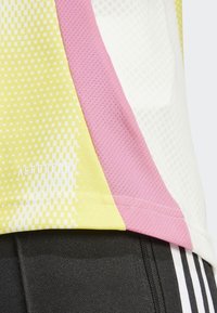 Herrtröja i sportmodell med nätfabric. Har färgblock i gult, rosa och vitt samt "AEROREADY"-logotyp nära f�ållen.