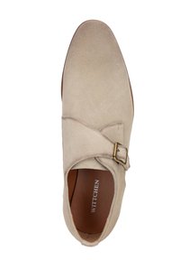 Beige semišová bota s kulatou špičkou, ozdobným křížovým páskem a kovovou přezkou. Vnitřek má hladké hnědé podšívání.