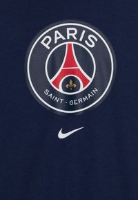 Námořnická bavlněná tričko s kulatým logem Paris Saint-Germain a malým bílým logem Nike na spodní části.