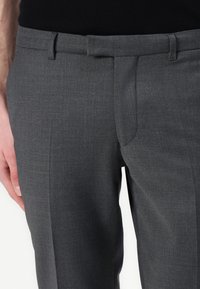 Grå skräddarsydda byxor med en slät yta, rak front och sidofickor. Har en klassisk passform och ett subtilt melerat tygmönster.