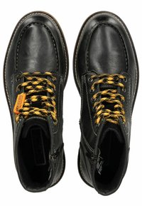 Botas de cuero negras hasta el tobillo con cordones amarillos y negros con patrón, punta redondeada, suela de goma y cremalleras laterales. Costuras reforzadas en toda la bota.