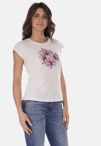 T-shirt in cotone bianco con stampa floreale in tonalità di rosa e viola, maniche corte, scollo tondo e vestibilità comoda.