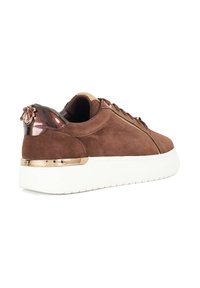 Brown suede sneaker with white rubber sole, gold metallic accent on heel, and glossy brown detail at the back. Textured upper and laces.