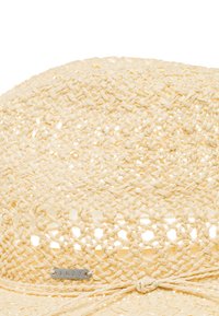 Světlobéžový slomkový klobouk se šitým vzorem, otevřeným designem a kovovým logem Roxy. Jemný, flexibilní materiál.