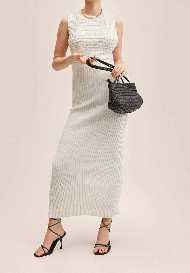 Dzianinowa, bezrękawnikowa, ryflowana maxi sukienka w kolorze off-white z dopasowanym korpusem. Uzupełniona o małą czarną plecioną torebkę oraz czarne sandały na obcasie.