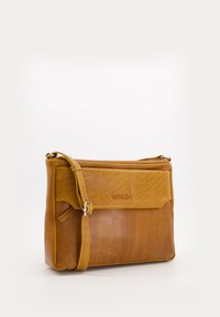 Brown leather shoulder bag with adjustable strap, flap front, and embossed logo. Textured finish with a polished look and spacious interior.