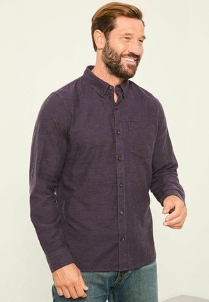 Dunkelviolette Hemdbluse mit einer Tasche, langen Ärmeln und einer Kragen. Der Stoff wirkt strukturiert und hat ein leicht lässiges Design.