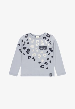 Chemise à manches longues gris clair avec des taches de léopard noires et argentées et le texte « COURAGE sur la peur » à l'avant.