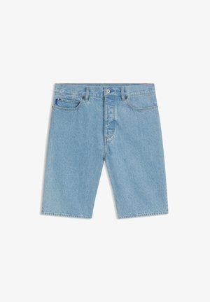Short en denim bleu clair avec bouton et fermeture éclair à l'avant, passants pour ceinture, poches avant, et une petite étiquette en tissu bleu sur la poche droite.