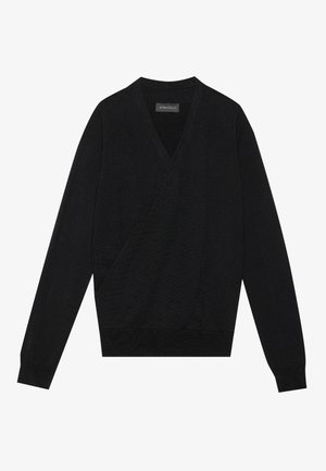 Zwarte wikkeltrui in een lichte breiwerk, met een V-hals en lange mouwen. Zachte textuur met een getailleerde taille en geribbelde zoomdetails.