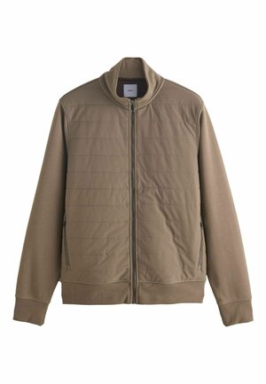 Giacca marrone con zip e colletto alto, frontale trapuntato e tasche laterali. Realizzata in un materiale morbido e leggero con polsini a coste.