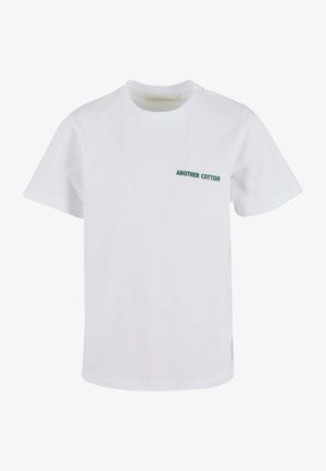 Hvid bomulds t-shirt med korte ærmer, der har et lille grønt tekstlogo "ANOTHER COTTON" på venstre side. Klassisk rund halsudskæring.