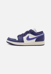 Baskets Nike Air Jordan 1 Low en blanc et violet, dotées d'une tige en cuir lisse, d'un bout rond, de lacets plats et d'une semelle en caoutchouc.