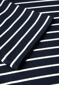 Tissu rayé bleu marine et blanc, texture côtelée, présentant une finition lisse avec des coutures régulières le long des bords.