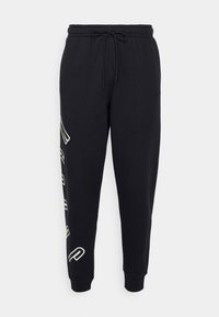 Pantalones deportivos negros con cintura ajustable, piernas entalladas, bolsillos laterales y letras blancas en la pierna izquierda. Tela suave con una textura lisa.