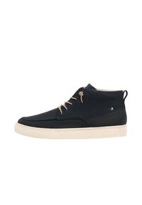 Chaussure mi-montante noire avec une tige en cuir lisse, lacets beige et semelle en caoutchouc de couleur claire. Présente un dos texturé et un détail de logo.
