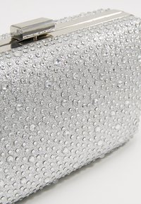 Clutch de soirée rectangulaire argenté recouvert de petits strass avec un fermoir métallique.