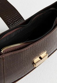 Borsa in ecopelle effetto coccodrillo marrone con chiusura a zip, accessori in metallo dorato e fodera interna nera.
