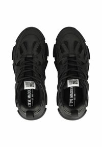 Zapatillas deportivas negras con una parte superior de malla texturizada, suela gruesa y un sistema de cordones prominente; presenta la marca en las plantillas y en el costado.