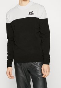 Czarny i biały sweter w stylu color-block z długimi rękawami, okrągłym dekoltem i dzianinową fakturą; z logo "KARL LAGERFELD" w kolorze czarnym.