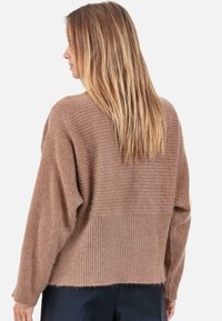 Pull en maille côtelée marron avec une coupe ample, présentant des sections texturées contrastantes et une finition douce et confortable. Manches longues, design décontracté.