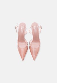 Ζευγάρι διαφανών ροζ μυτερών γοβών με λουράκια τύπου slingback και αγκράφες, παρουσιάζονται από πάνω σε λευκό φόντο.