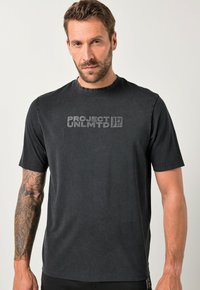 Černé tričko s krátkým rukávem vyrobené z bavlny, se zvýšenou grafikou "PROJECT UNLMTD" uprostřed. Jednoduchý kulatý výstřih, měkká textura.