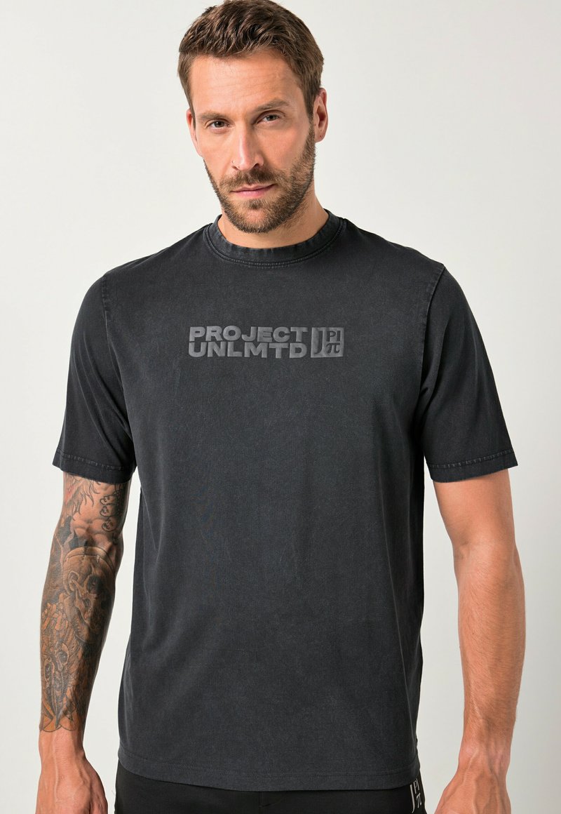 Černé tričko s krátkým rukávem vyrobené z bavlny, se zvýšenou grafikou "PROJECT UNLMTD" uprostřed. Jednoduchý kulatý výstřih, měkká textura.