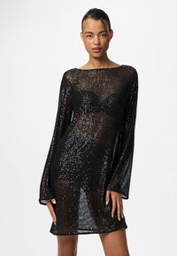 Vestido preto com lantejoulas, de design solto e transparente, mangas largas e decote barco. Apresenta corpete ajustado e silhueta descontraída.