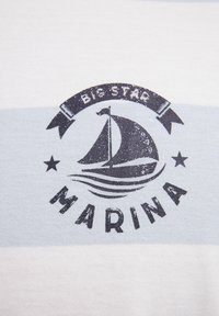 Puuvillane T-särk, millel on sinised ja valged horisontaalsed triibud, keskosas purjelaeva graafika ja must kiri "BIG STAR MARINA".