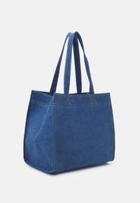 Torba tote z denimu w ciemnoniebieskim kolorze, z dwoma ramiączkami, w kształcie kwadratu, z widocznym żółtym ściegiem oraz płaskim dnem dla stabilności.