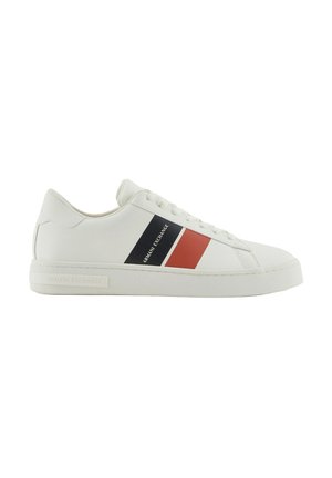 Sneaker bianche in pelle con una texture liscia, caratterizzate da strisce rosse e blu navy sui lati e una suola in gomma. Branding sul tallone.