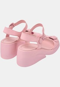 Rosa plattformssandaler med breda remmar, justerbara spännen, öppen tå-design och en slät yta. Klacken har en rund, chunky form.