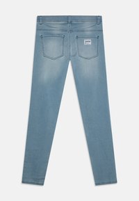 Jeans in denim azzurro chiaro con un design aderente, dotati di due tasche posteriori, una leggera scoloritura e un'etichetta con il marchio in vita.