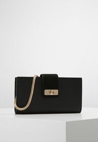 Black faux leather handbag with a rectangular shape, gold chain strap, and magnetic clasp. Smooth texture with a velvet accent on the clasp.