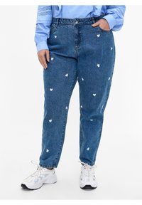 Zilās džinsa bikses ar brīvu piegriezumu, kā arī ar baltām sirds zīmēm visā virsmā. Apvienotas ar baltām kedām, radot ikdienišķu izskatu.