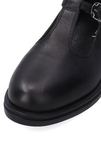 Schwarzer Lederschuh mit runder Zehenpartie, seitlichen Ausschnitten und einem Riemen mit silberner Schnalle, ausgestattet mit einer flachen, schwarzen Sohle mit dezentem Muster.