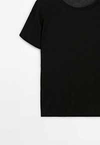 T-shirt noir à manches courtes uni avec col rond sur fond blanc.