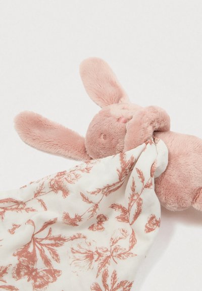 Cabeça de coelho de pelúcia rosa com orelhas longas, segurando um tecido creme com padrões florais em rosa e ferrugem. Textura macia.