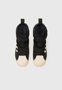 Botas acolchadas negras con una parte superior texturizada, puños elásticos y una puntera de goma color crema. Presenta tres rayas blancas en el costado.