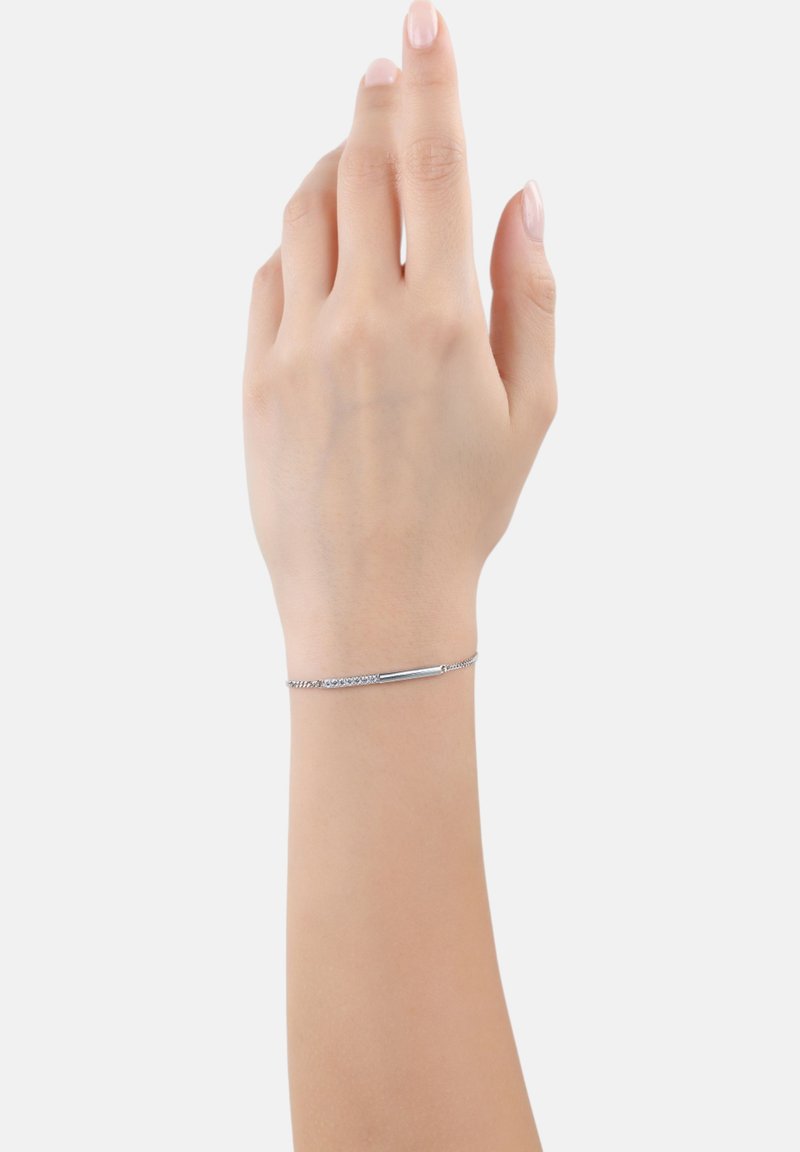 Brazalete de cadena de plata delicada con un centro de barra alargada. Cuenta con un cierre simple y un acabado suave, complementando un diseño minimalista.