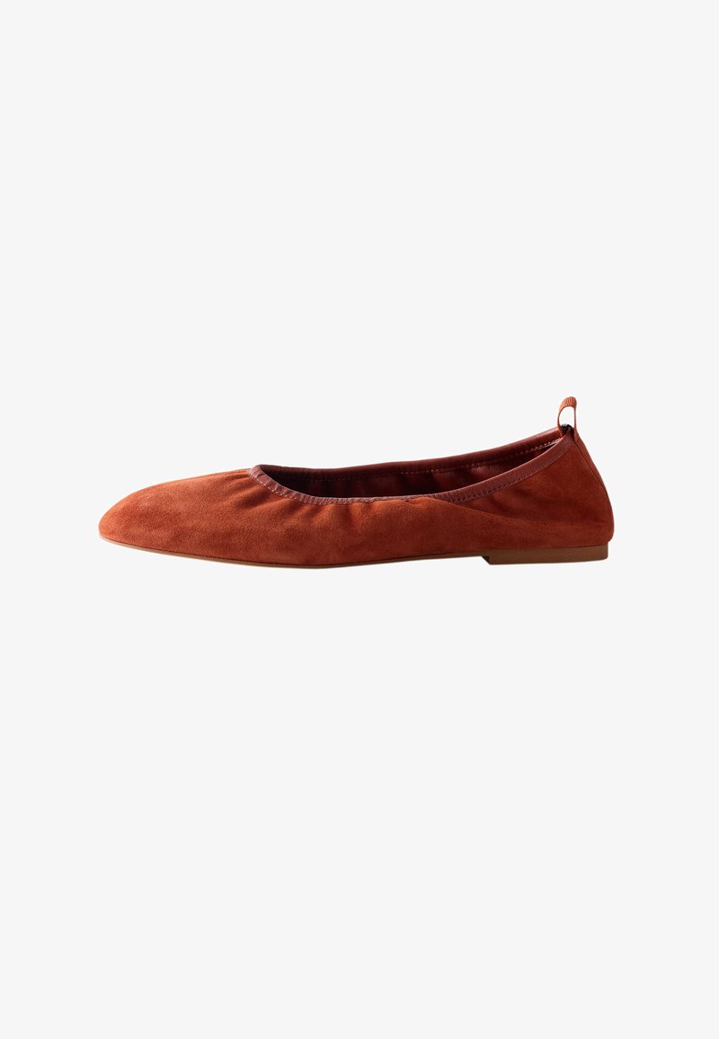 Chaussure de ballet plate en daim marron avec bout arrondi, petit talon et languette en tissu au talon, présentée en profil latéral sur fond blanc.