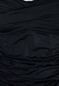 Maillot de bain noir une pièce avec détail de tissu froncé. Texture lisse, matériau extensible et design à bretelles croisées au niveau du buste.