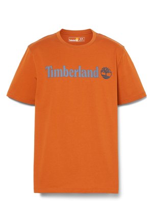 Orange bomulds t-shirt med korte ærmer, rund halsudskæring og blå "Timberland" tekst ved siden af et trælogo. Glat tekstur, afslappet design.