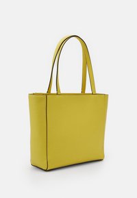 Gul totebag med glat tekstur, rektangulær form, dobbelte håndtag og sort kant langs kanterne. Rent, minimalistisk design.