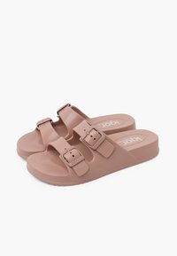 Infradito in gomma rosa con due fibbie regolabili, suola testurizzata e pianta piatta. Design leggero adatto per un uso informale.