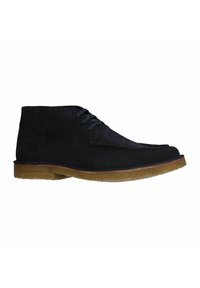 Bottines en suède noir avec des lacets gris, un bout arrondi et une semelle en caoutchouc brun clair. Présente une couture le long du bout et sur le côté.